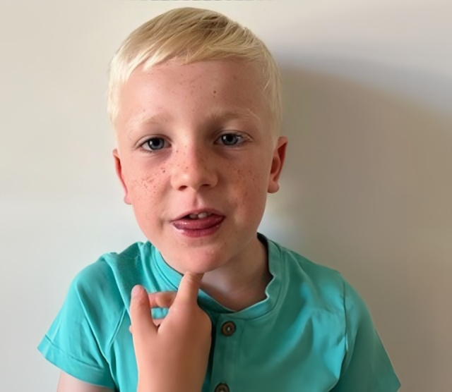 A boy with his finger on his Adams apple